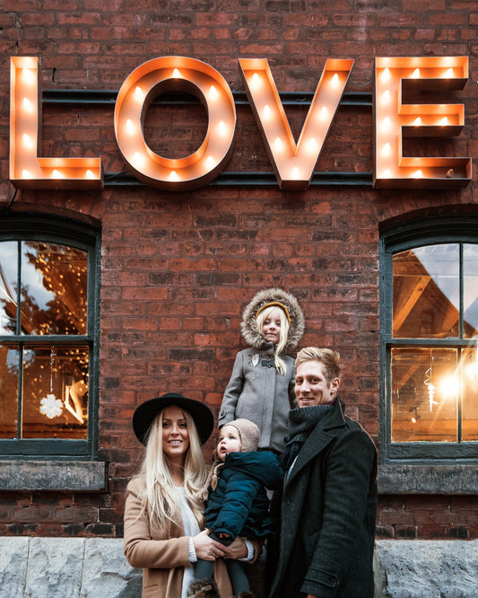 Young Beautiful Family Together under Big sign of Love