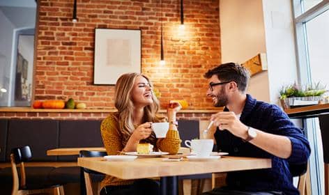 Men's Dating Coach | How to Meet the Girl of Your Dreams | Attractive Young Couple laughing over a cup of coffee at a coffee house