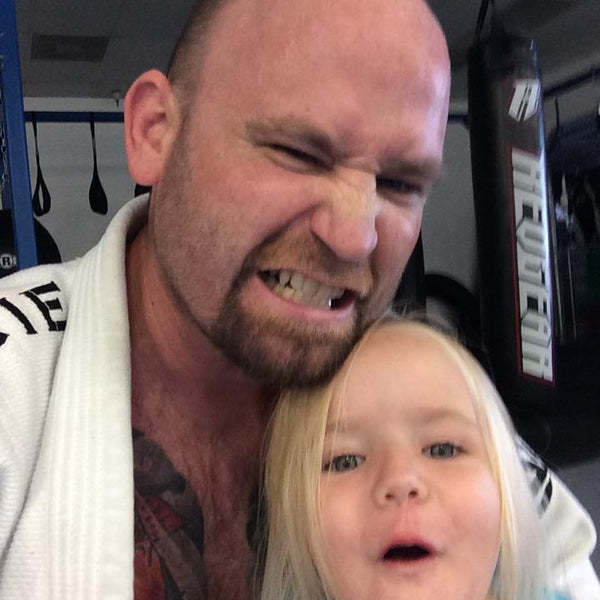 Professional MMA Fighter and Kickboxer Tony Sanza wearing his Gracie Gi holding his Daughter | Sports Hypnosis with Mike Kollin Sports Hypnotherapist