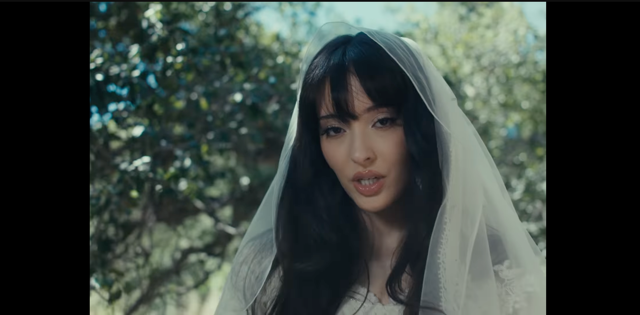 Load video: Beautiful Young lady in Forrest with tattoos all over her arms and body covering her right eye wiht right hand with tattoos next to a tree wiht a butterfly on her thumb! Song Die for you from Ashes to New