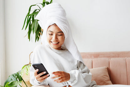 talk therapy now | Young asian women with wet hair wrapped up in white towel while talking on her phone with talk therapist